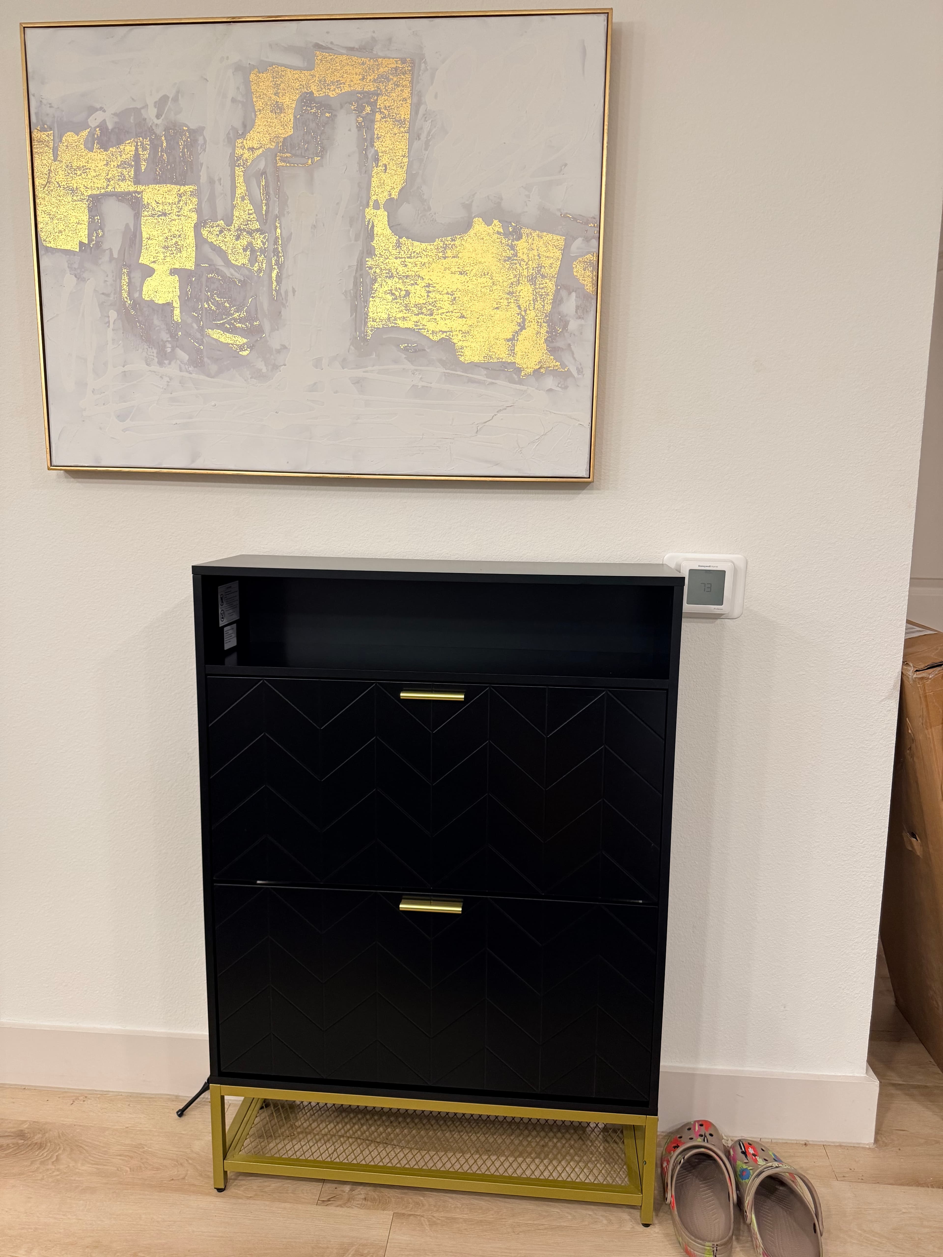 Black chevron-pattern cabinet with gold handles