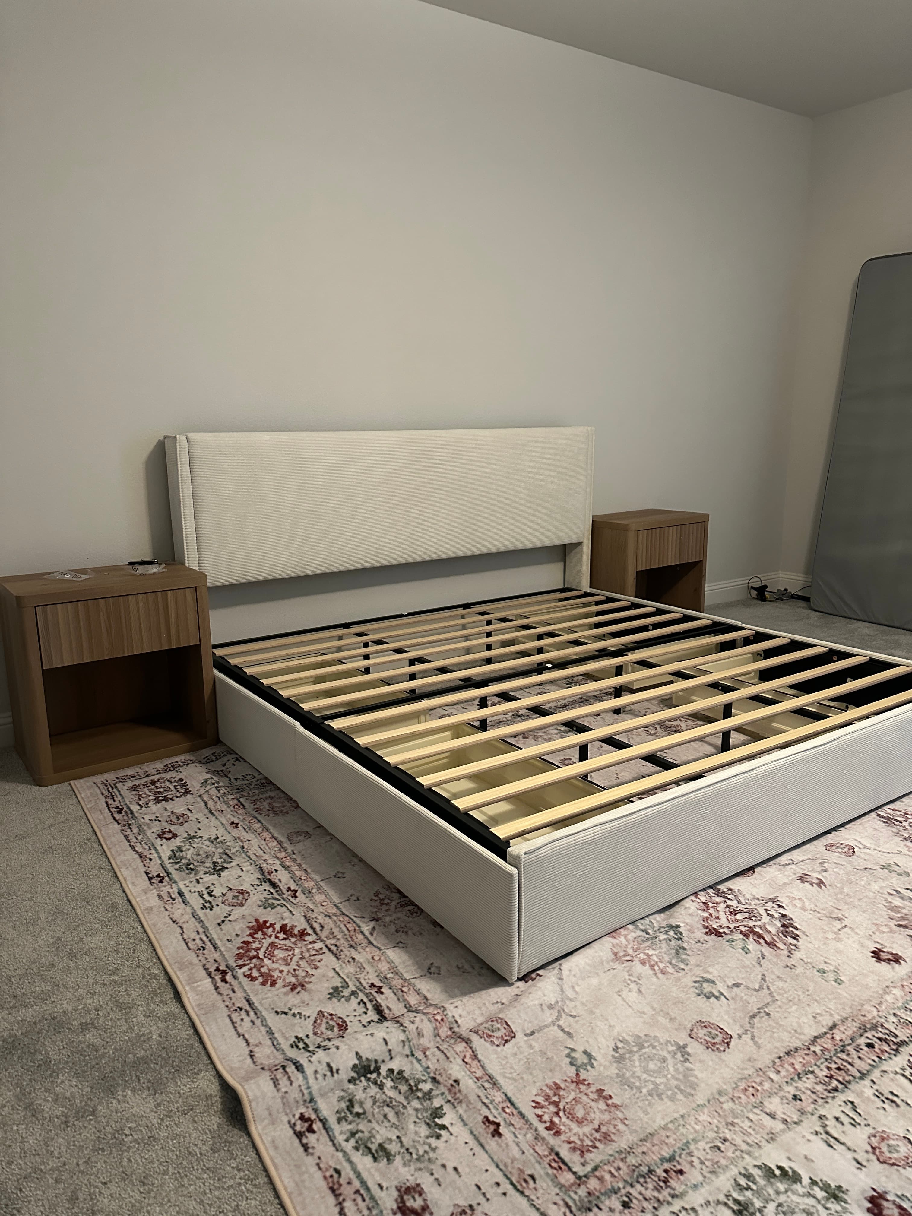 Gray upholstered bed frame with wooden nightstands