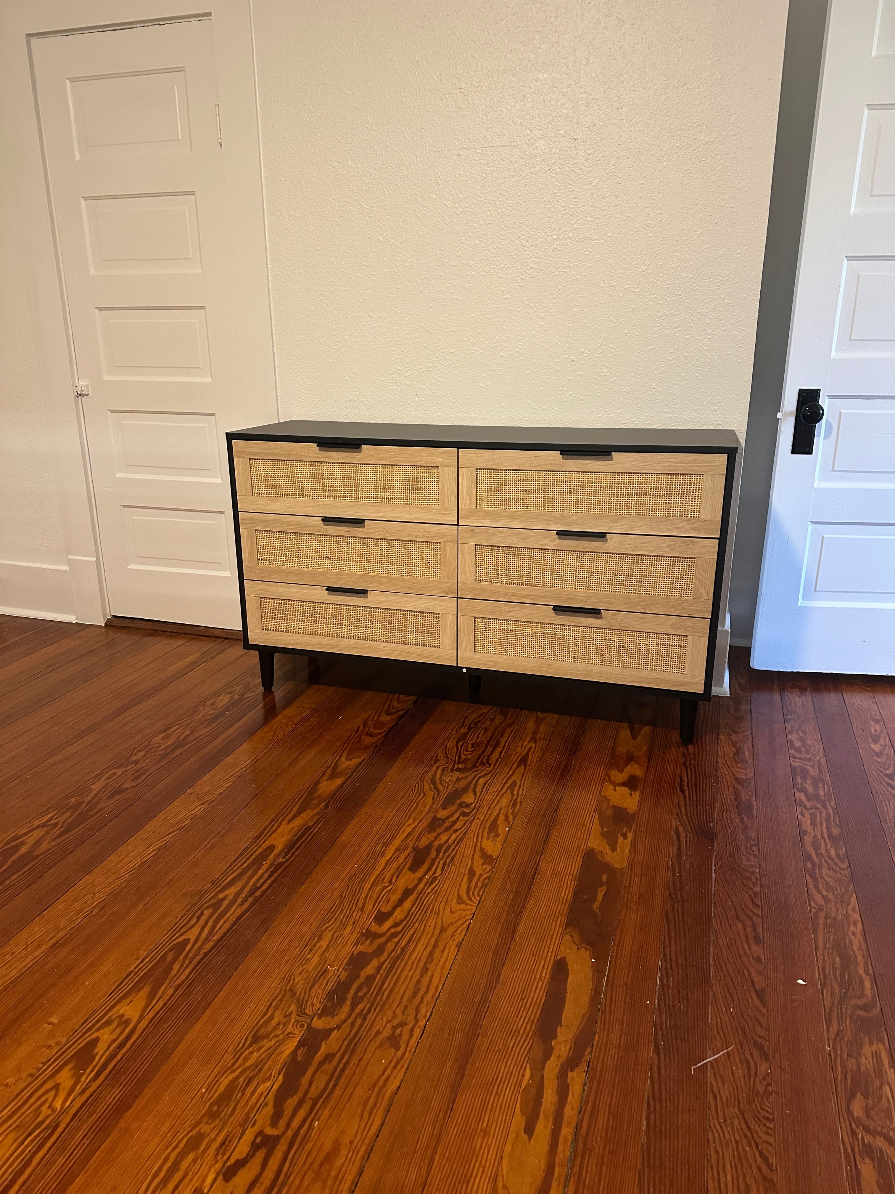 Small black cabinet with rattan woven doors