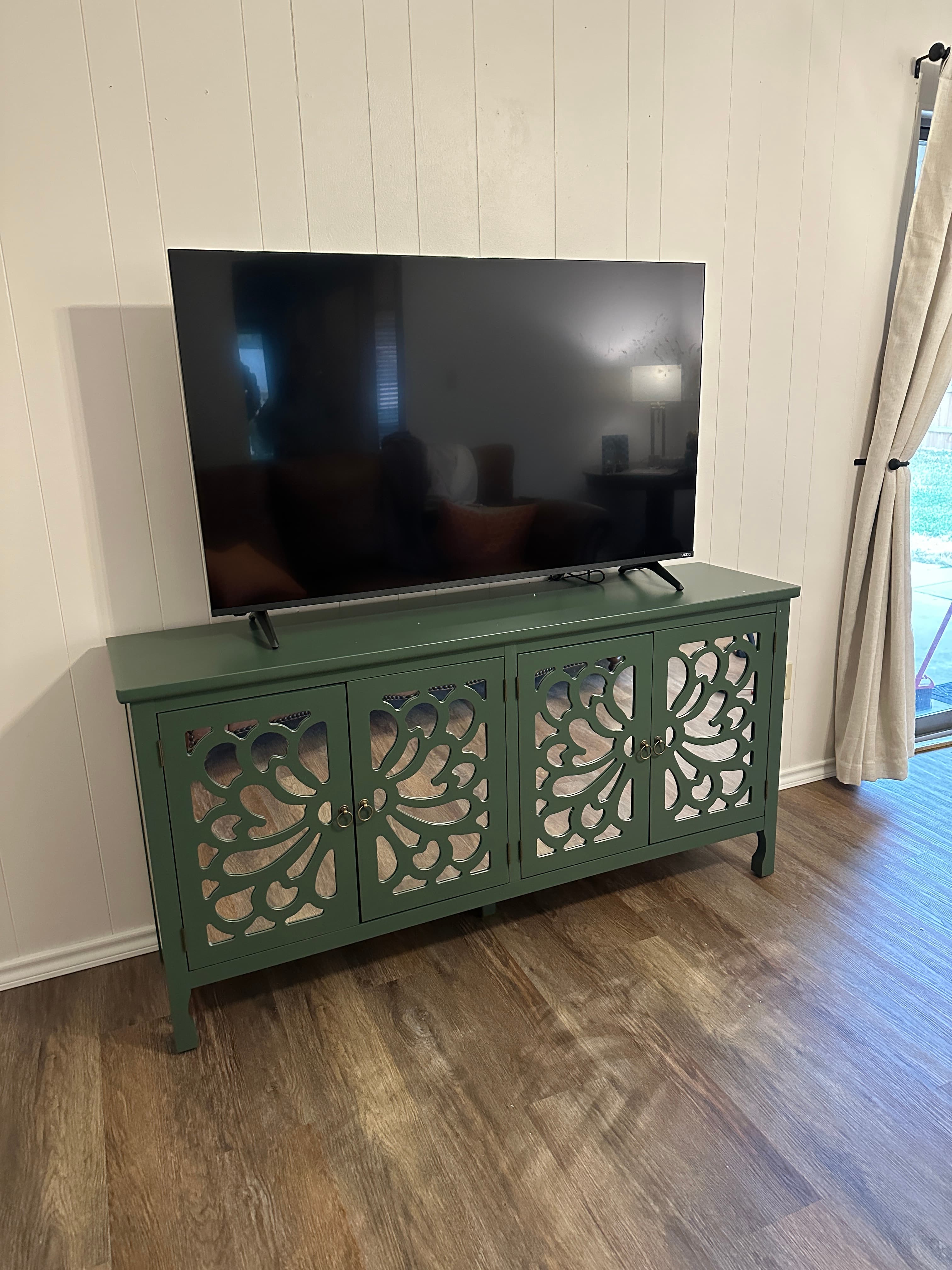 Green ornate TV stand with decorative panel doors