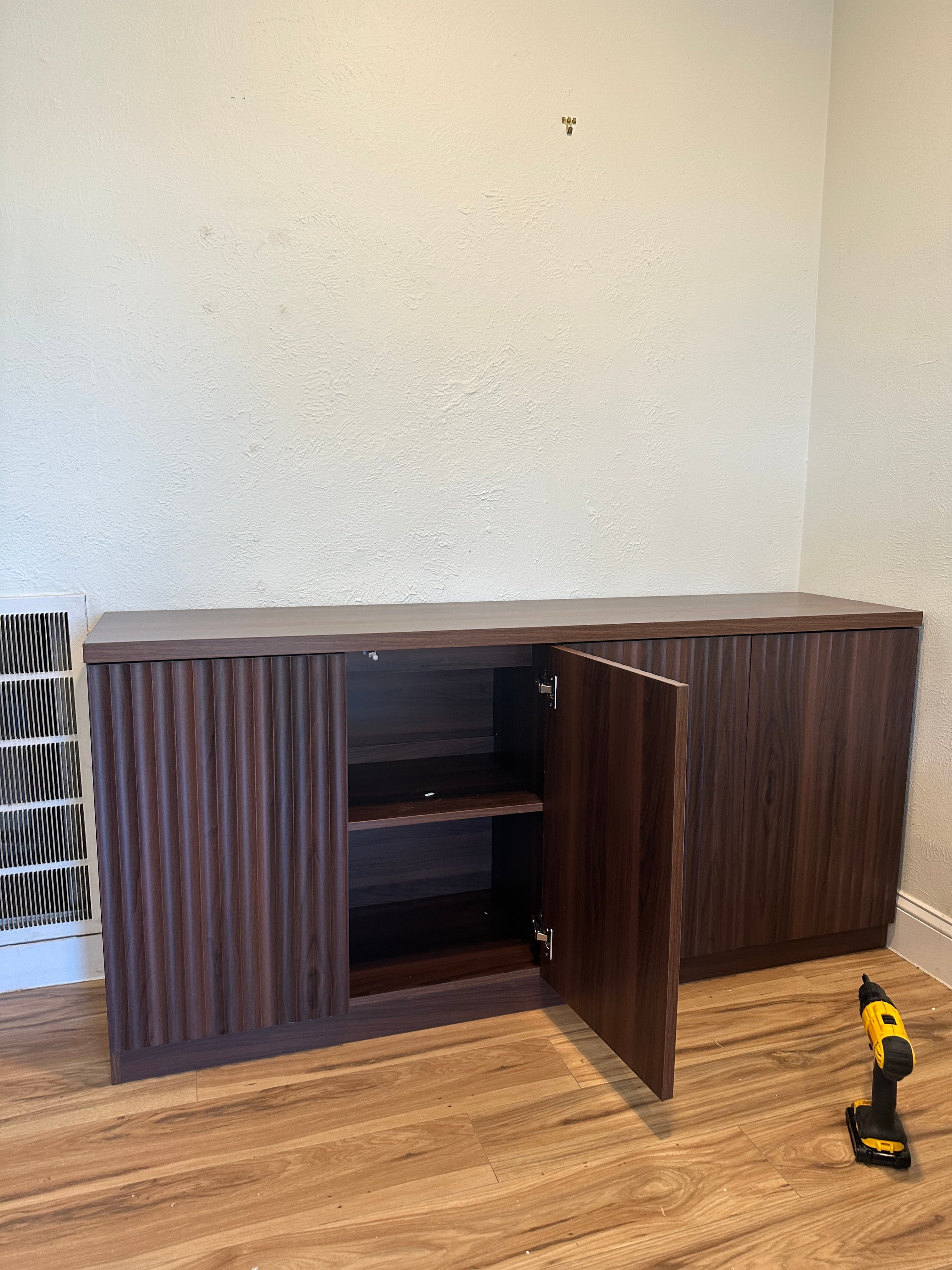 Dark brown cabinet with slatted front and open compartment