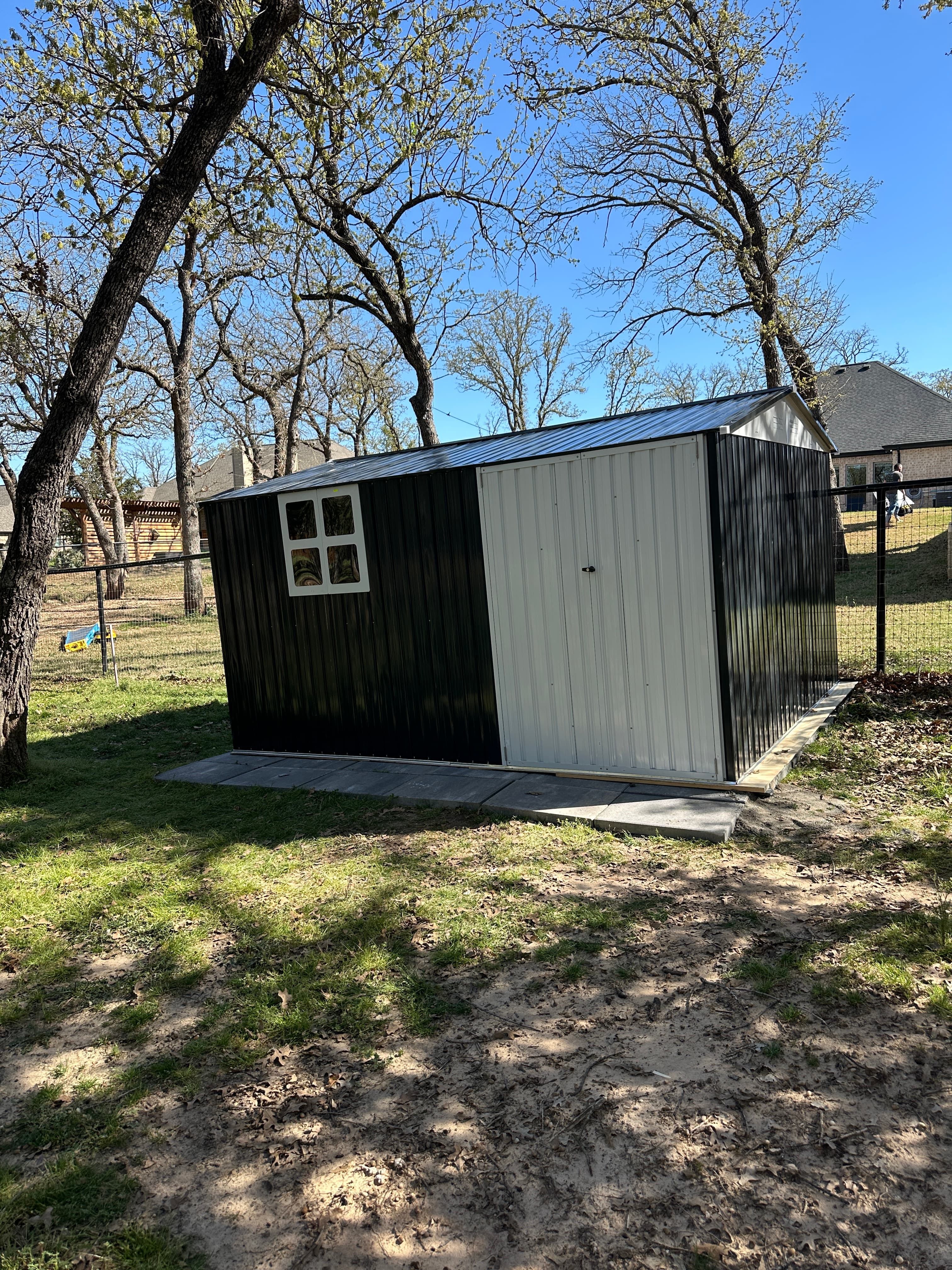 Small wooden shed with black and white finish